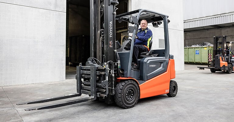 Chauffeur in een Toyota Traigo elektrische heftruck in een magazijn.